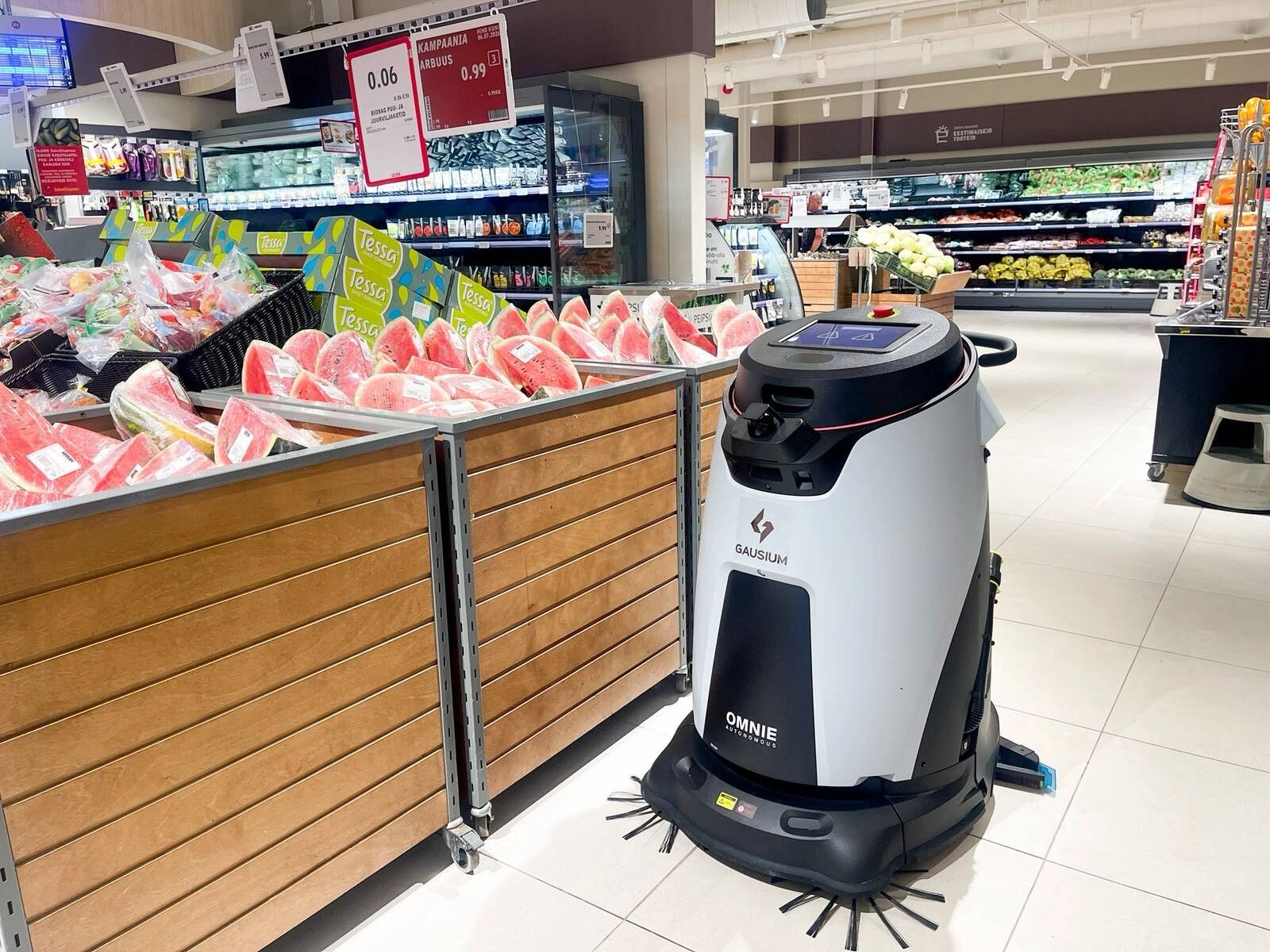 Gausium OMNIE floor scrubber cleaning a supermarket produce aisle